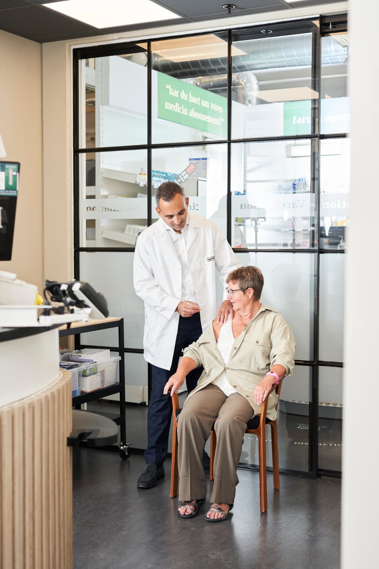 Farmaceut giver vaccination til kunde i vaccinationsrummet på Farum Apotek
